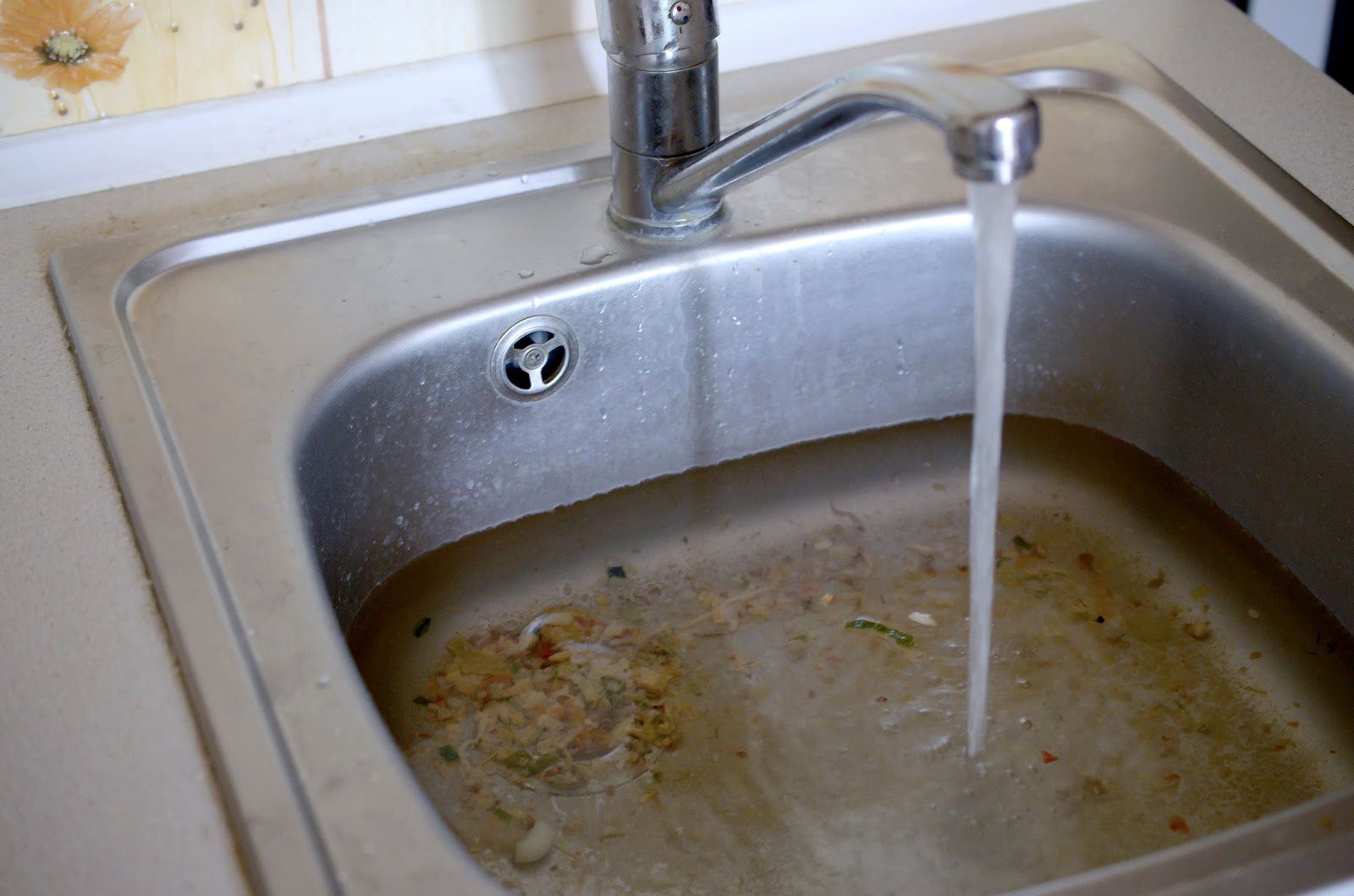 Too much food in the garbage disposal has caused a clogged kitchen sink