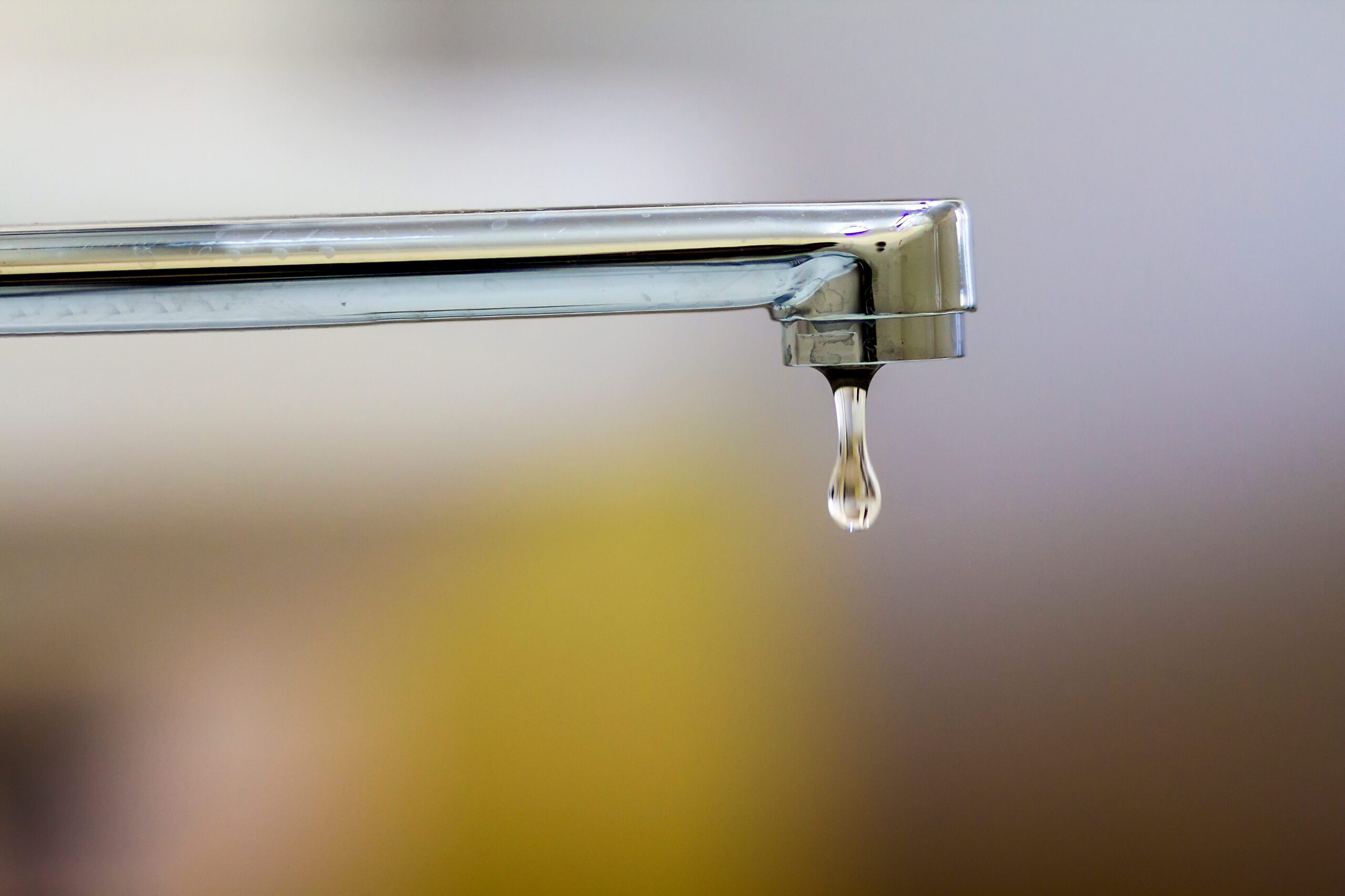 Close-up of faucet with turned drop water in modern bathroom. Horizontal crop with shallow depth of field