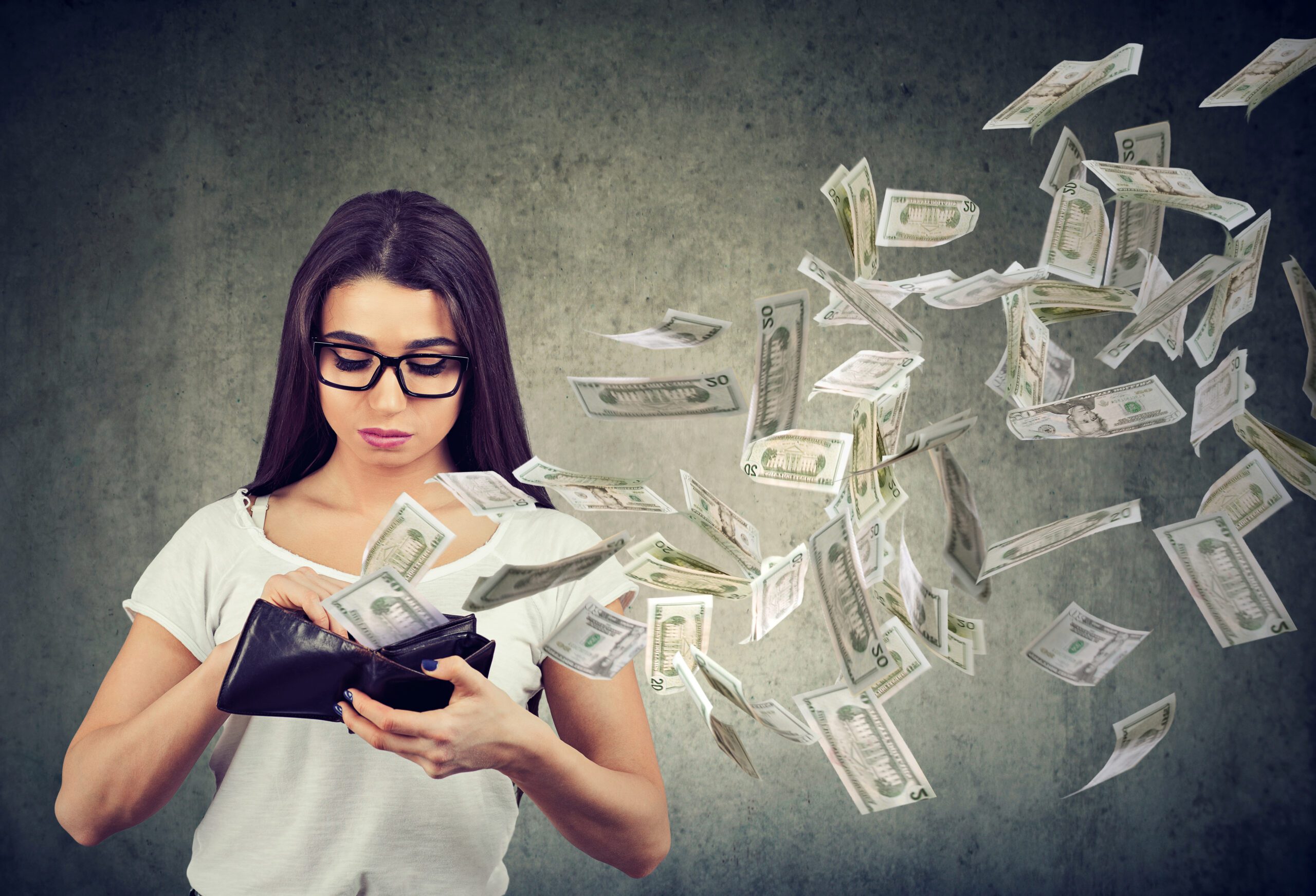 Sad woman looking at her wallet with money dollar banknotes flying out away because of emergency HVAC repair costs