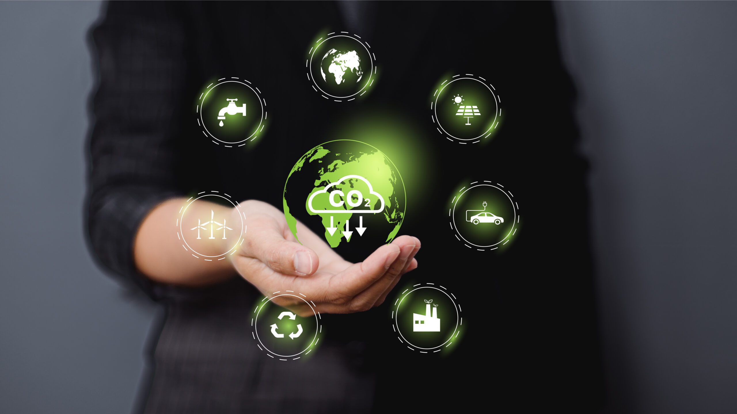 Hand holding virtual Globe with CO2 reducing icon for concept of decreasing carbon dioxide emission, carbon footprint and carbon credit to limit global warming from climate change concept