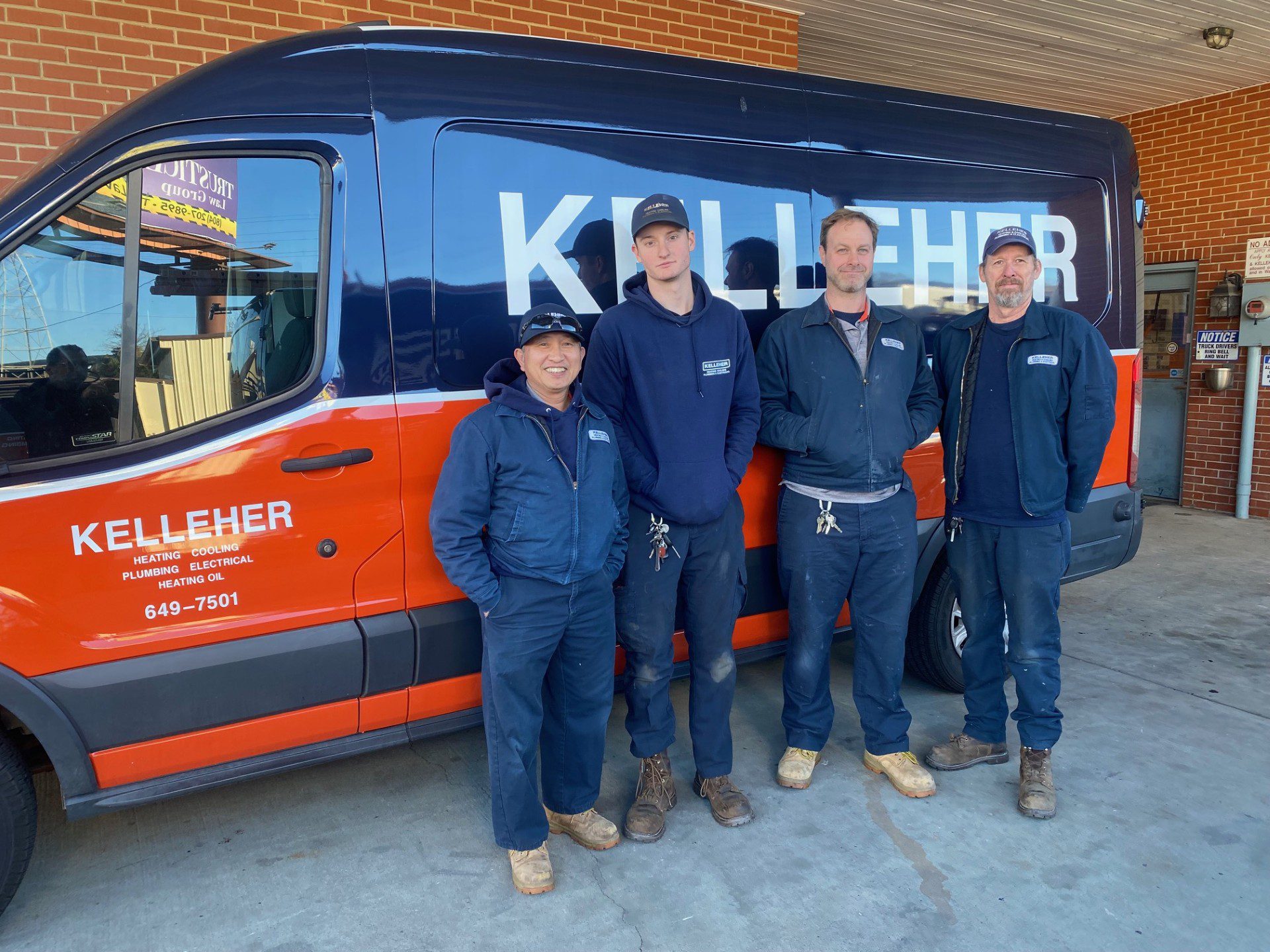 Team photo showing the Kelleher HVAC Install Team, Kelleher HVAC service vehicle behind the group of four.
